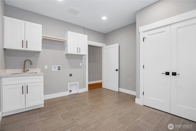 laundry area with baseboards, cabinet space, electric dryer hookup, washer hookup, and a sink