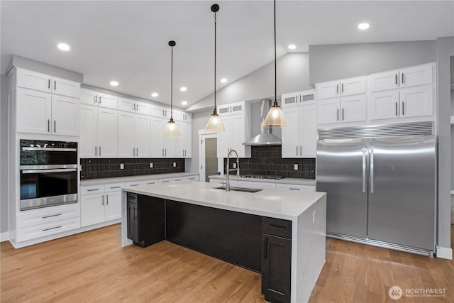 kitchen with wall chimney range hood, light wood-style floors, white cabinets, and stainless steel appliances