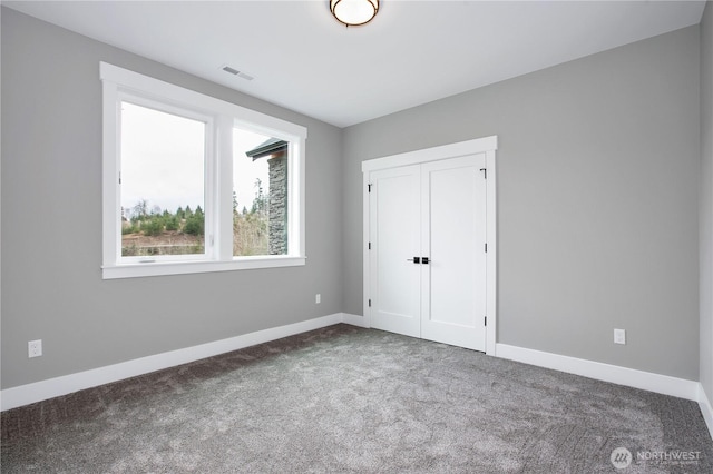 unfurnished bedroom with visible vents, carpet floors, and baseboards