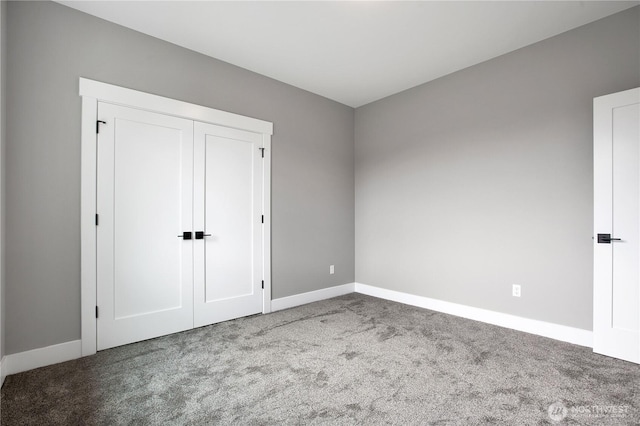 unfurnished bedroom with a closet, baseboards, and carpet