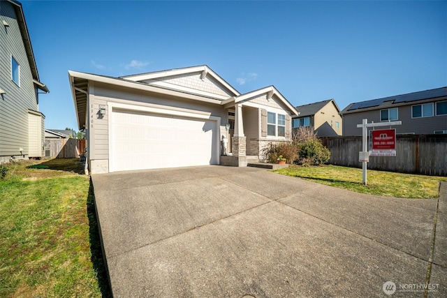 view of front of house featuring an attached garage, concrete driveway, a front yard, and fence