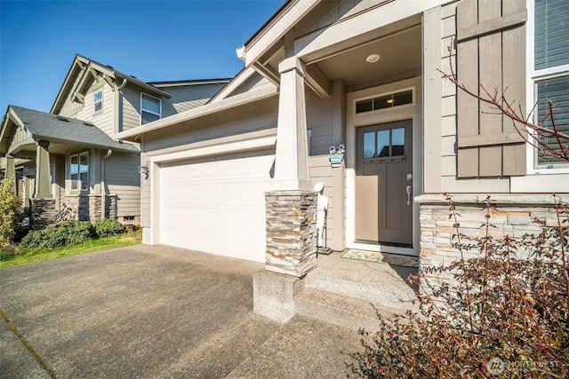 doorway to property with driveway and a garage