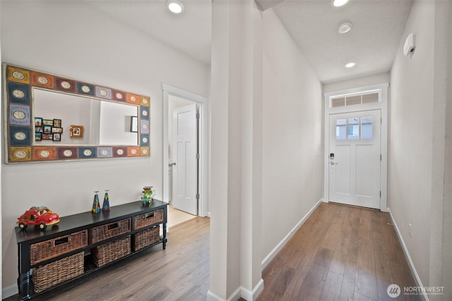 hall with visible vents, recessed lighting, baseboards, and wood finished floors