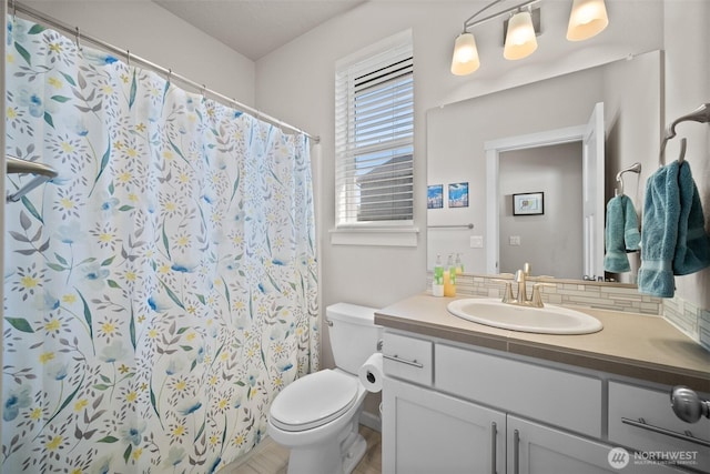 bathroom featuring vanity, toilet, a shower with curtain, and tasteful backsplash