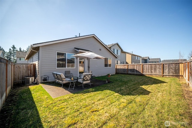 back of property with a yard, a fenced backyard, and central AC