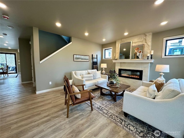 living room featuring recessed lighting, a fireplace, and wood finished floors