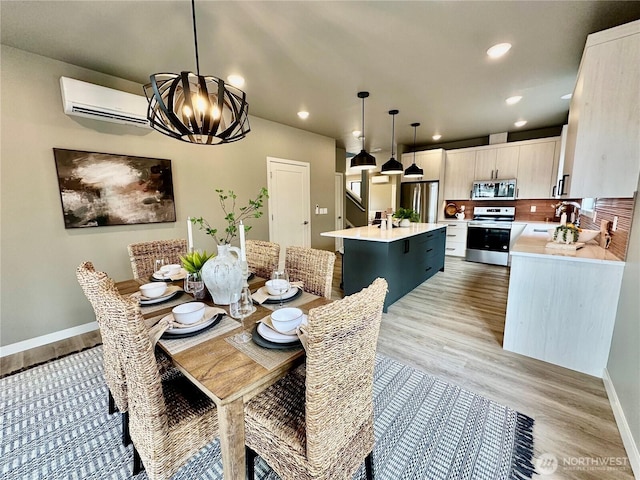 dining room with recessed lighting, baseboards, light wood-style floors, and a wall mounted AC