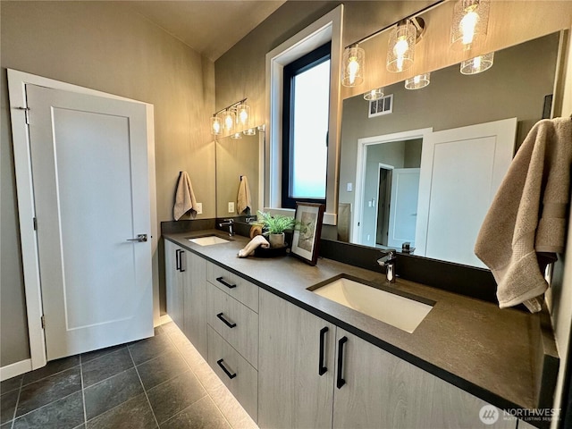 bathroom featuring double vanity, visible vents, and a sink