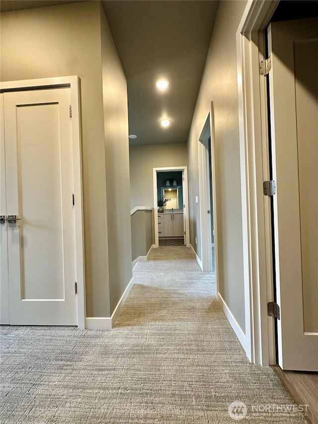 hallway featuring recessed lighting, baseboards, and carpet floors