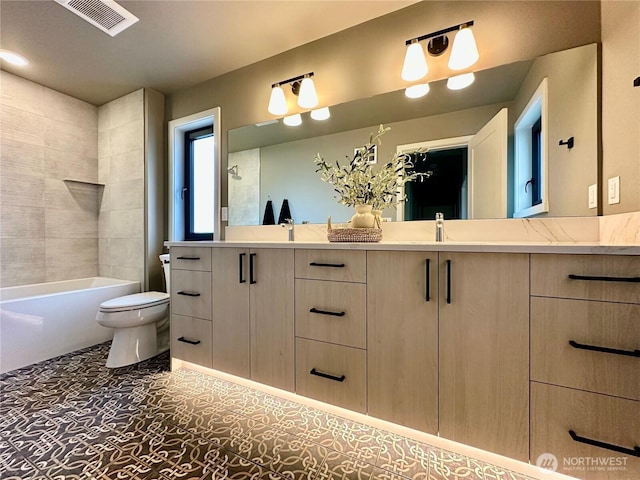 bathroom featuring double vanity, toilet, visible vents, and bathing tub / shower combination