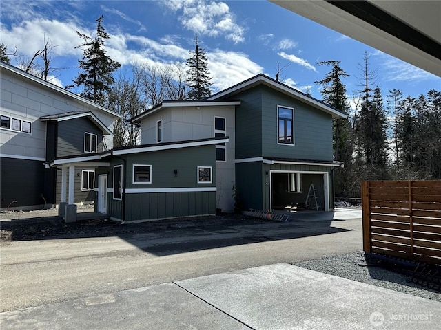 rear view of house featuring fence and a garage