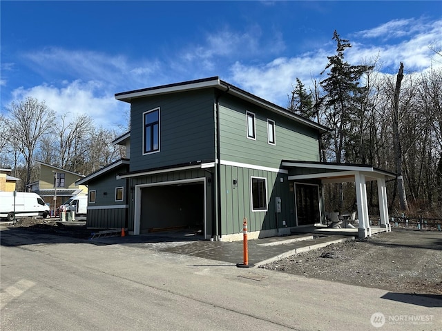 view of front of property with driveway, board and batten siding, and an attached garage