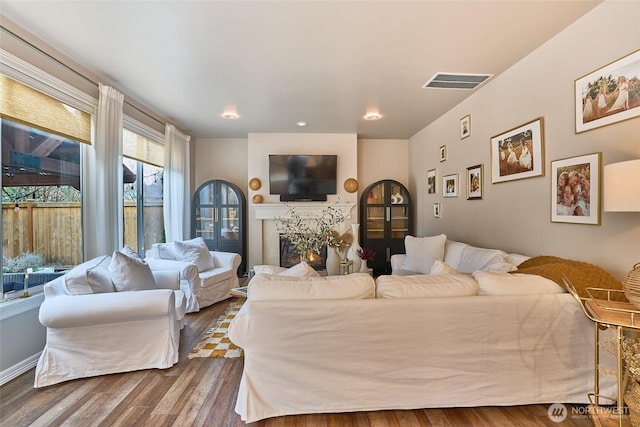 living room featuring visible vents, dark wood finished floors, and a fireplace