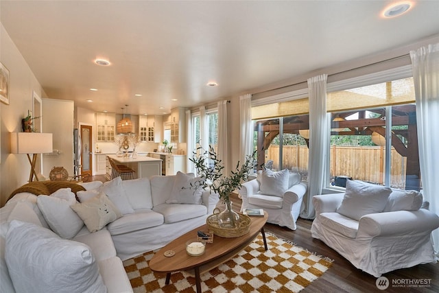 living room with recessed lighting, plenty of natural light, and dark wood-style flooring