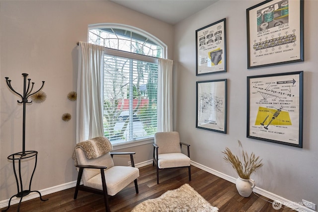 sitting room with baseboards and dark wood-style flooring