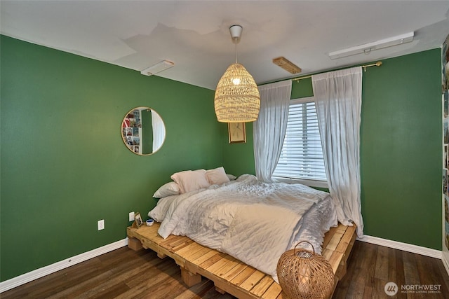 bedroom with wood finished floors and baseboards