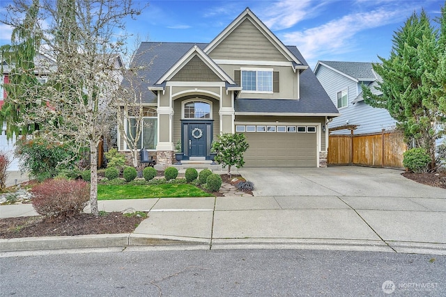 view of front of property featuring fence, concrete driveway, roof with shingles, a garage, and stone siding