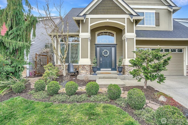 entrance to property with stone siding, driveway, a garage, and roof with shingles