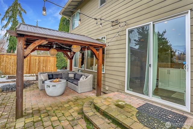 view of patio / terrace with a gazebo, an outdoor living space with a fire pit, and fence