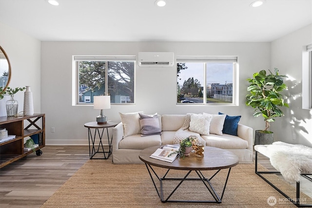 living room with a wall unit AC, recessed lighting, wood finished floors, and a wealth of natural light