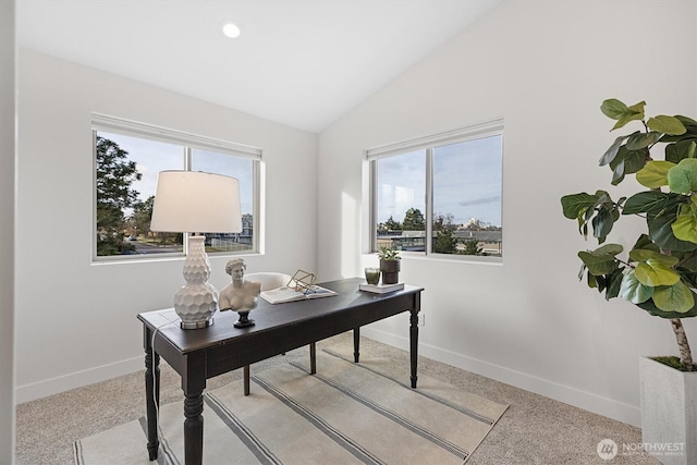 office area with lofted ceiling, baseboards, and light carpet