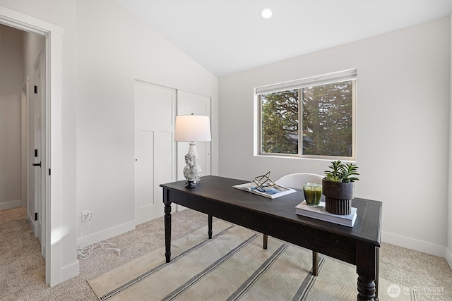 carpeted office space with baseboards and lofted ceiling