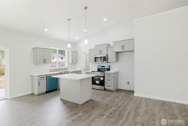 kitchen with gray cabinetry, a sink, a kitchen island, appliances with stainless steel finishes, and light countertops