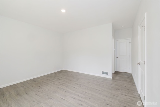 unfurnished room with recessed lighting, light wood-type flooring, baseboards, and visible vents