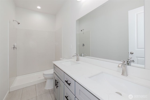 full bathroom with double vanity, toilet, a shower, and a sink