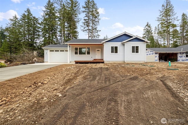 view of front of property with a porch, an attached garage, and driveway