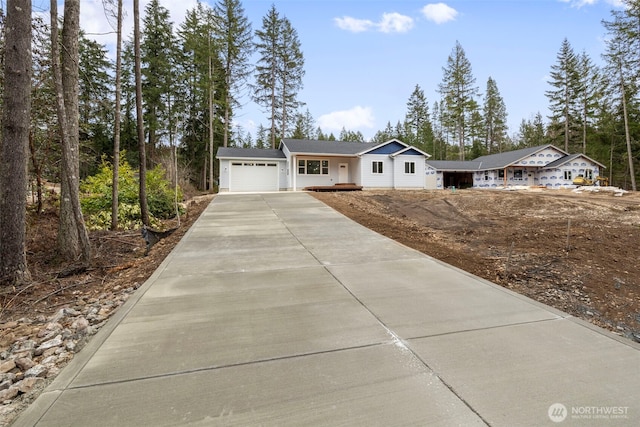 ranch-style home featuring concrete driveway and an attached garage