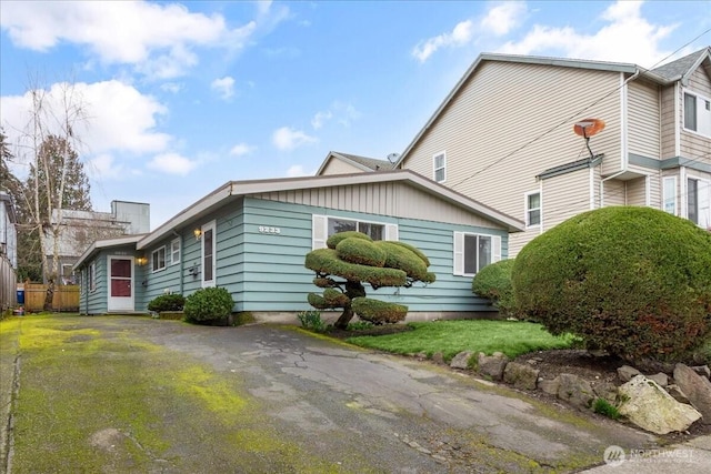 view of front facade featuring aphalt driveway and a front yard