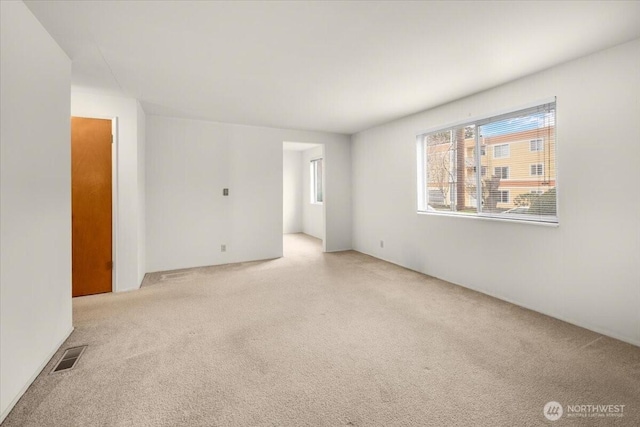 empty room with visible vents and carpet flooring