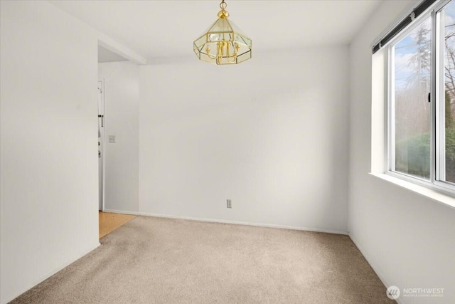 unfurnished room featuring carpet floors and a notable chandelier