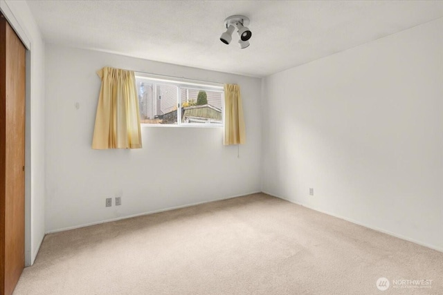 unfurnished room featuring light colored carpet