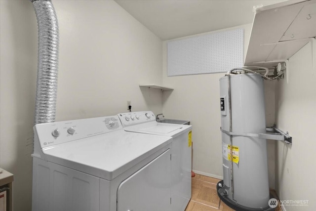 washroom with water heater, laundry area, and washing machine and dryer