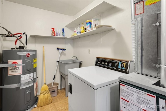 laundry room with secured water heater, washer / dryer, light wood-style flooring, and laundry area