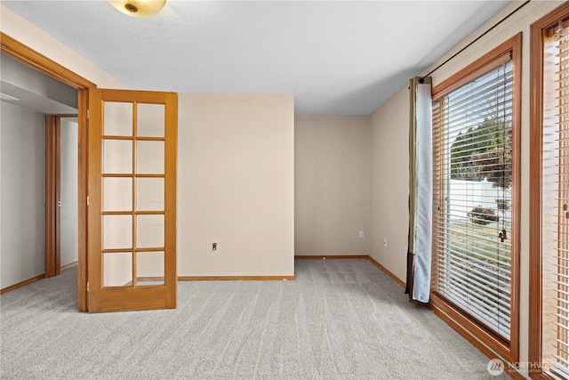 carpeted empty room featuring baseboards