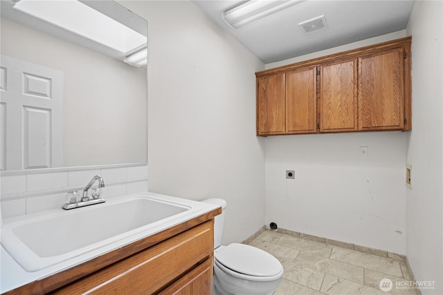 bathroom with vanity, toilet, baseboards, and visible vents