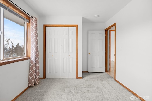 unfurnished bedroom with carpet flooring, baseboards, and a closet