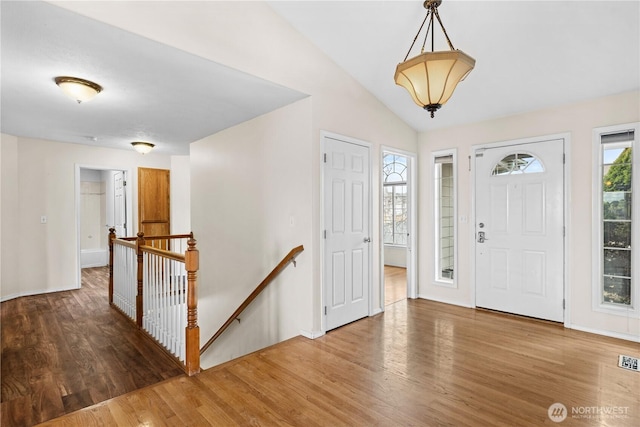 entryway with visible vents, wood finished floors, and vaulted ceiling