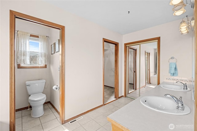 bathroom with tile patterned floors, toilet, visible vents, and a sink