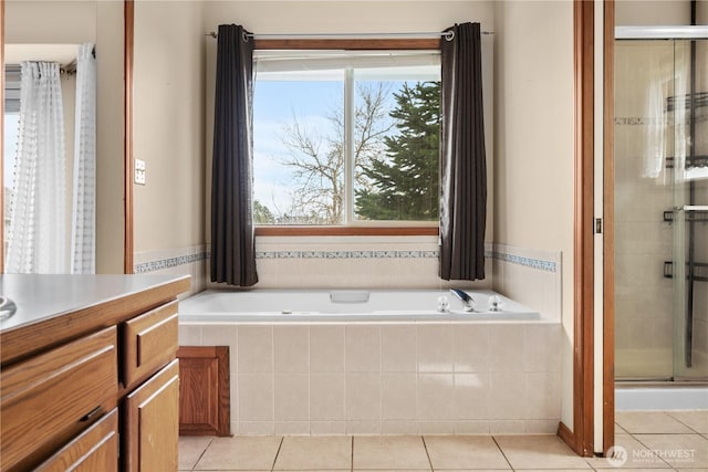 full bathroom featuring tile patterned floors, a stall shower, vanity, and a garden tub