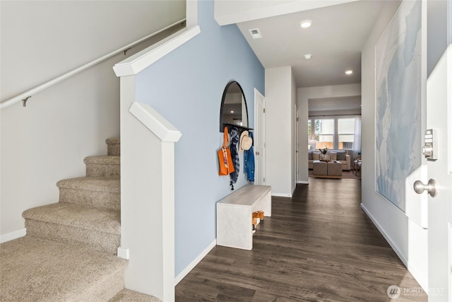 entryway featuring visible vents, baseboards, wood finished floors, and stairway