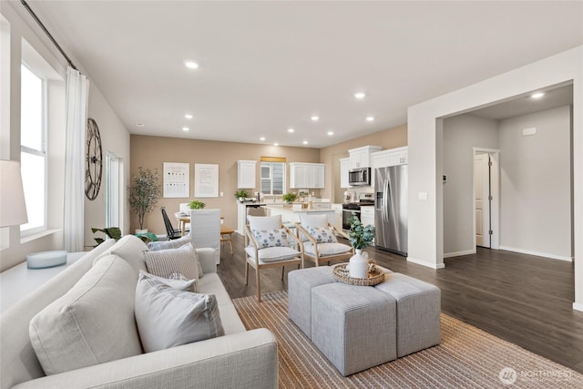 living room featuring dark wood finished floors, recessed lighting, and baseboards