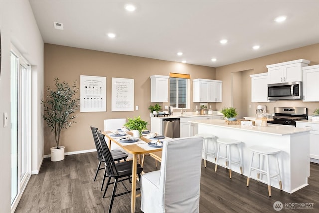 dining room featuring recessed lighting, dark wood-type flooring, and baseboards