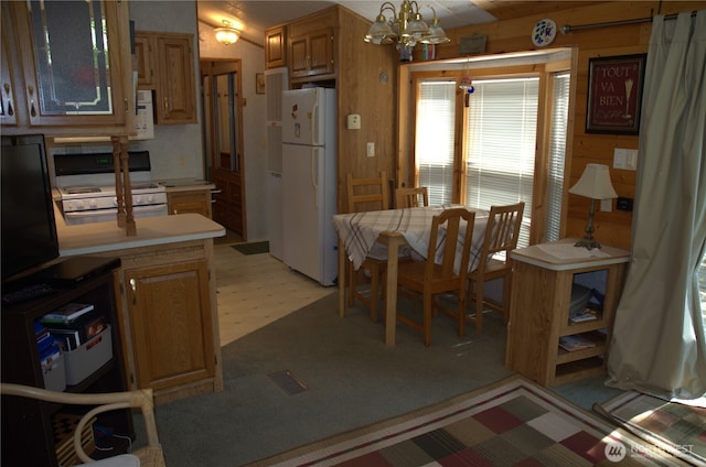 kitchen with white appliances, light countertops, and an inviting chandelier