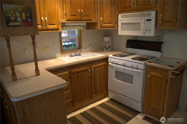 kitchen featuring a sink, white appliances, brown cabinetry, and light countertops