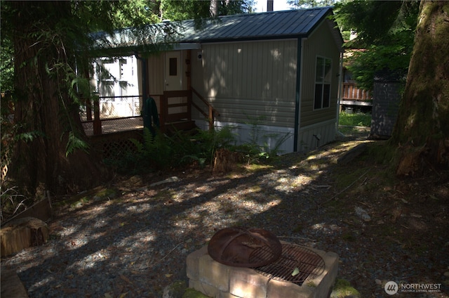 exterior space with a fire pit and metal roof