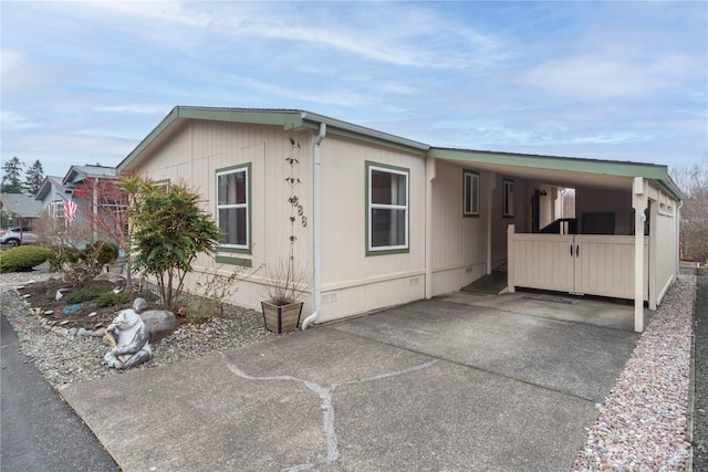 view of home's exterior with crawl space, an attached carport, and concrete driveway